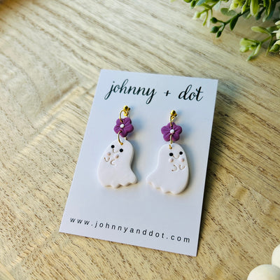 Pair of ghost-shaped earrings with purple flowers on a 'johnny + dot' card.