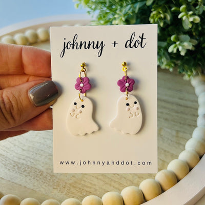 Pair of ghost-shaped earrings with floral details on a 'johnny + dot' card.