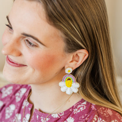 Model wearing a pair of Beaded Pastel Rainbow Cloud Flower Teacher Earrings