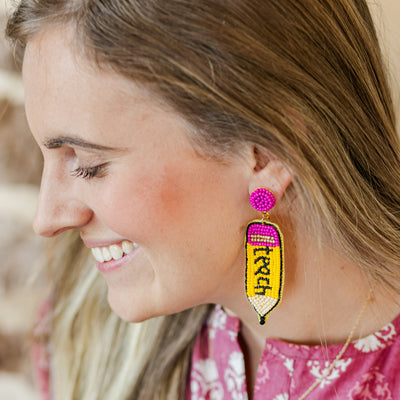Model wearing beaded pencil earrings. 