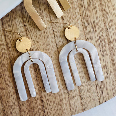 Resin double arch dangle earring in white marble with round gold accent.