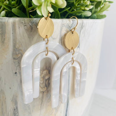 Resin double arch dangle earring in white marble with round gold accent.